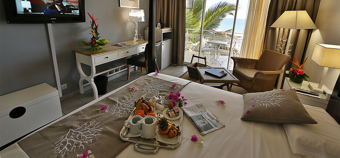 Hotel room with room service placed on the bed surrounded by flowers