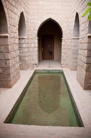 A green tinted fountain in an La Maison Timbuktu