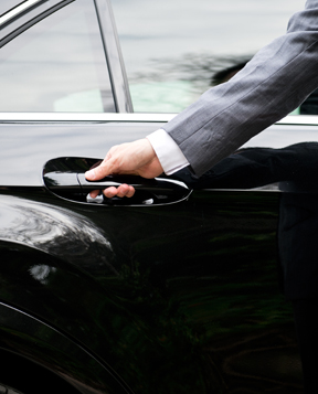 Man in suit driving a car