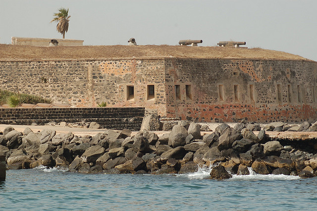 An historic castle site with waves crashing against a rocky shoreline