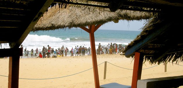 Many people crowding in the waves of a beach - Discover Cote D’Ivoire