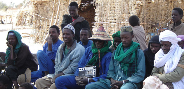 A group of men dressed in blue and green clothing smiling - Bamako and Segou