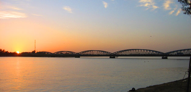 A long bridge silhouetted by a sunset - Tour of Saint Louis