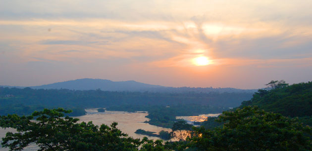 View of a grassy landscape with a river running through the land - Uganda Gorilla Tracking Safari