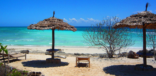 A resting area on a beach with large umbrellas and lounging chairs - Tanzania & Zanzibar Deluxe