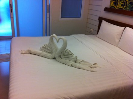Hotel room with one bed and a swan made of towel on the bed