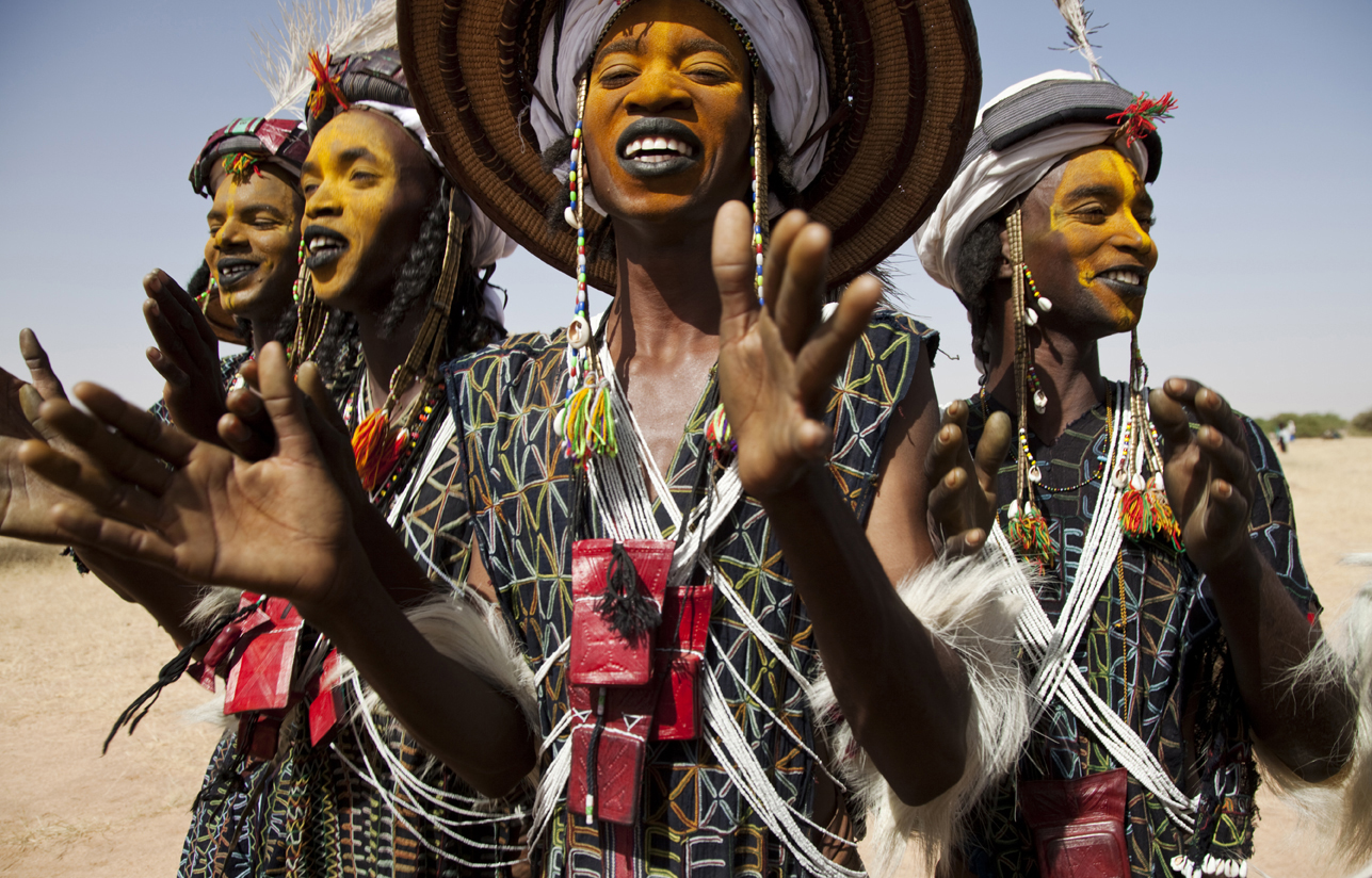 Women adorn with extravagant accessories with orange face paint - Gerewol Festival