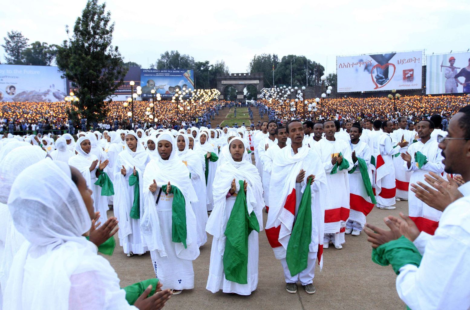 Men and women dressed in white, green and red at a festival